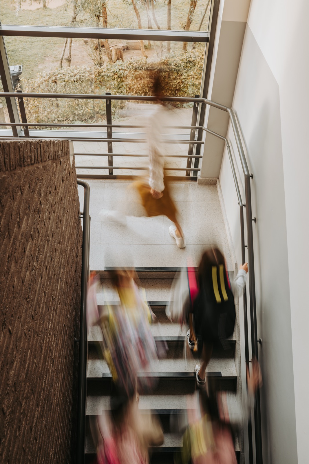 Leerlingen lopen met hun boekentas de trap op